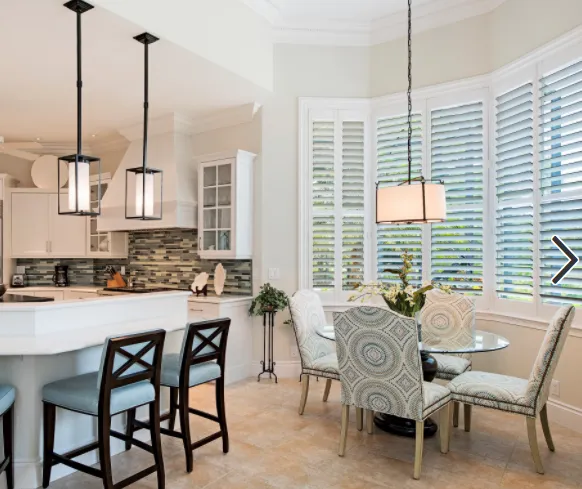 White plantation shutters around a bright kitchen breakfast nook