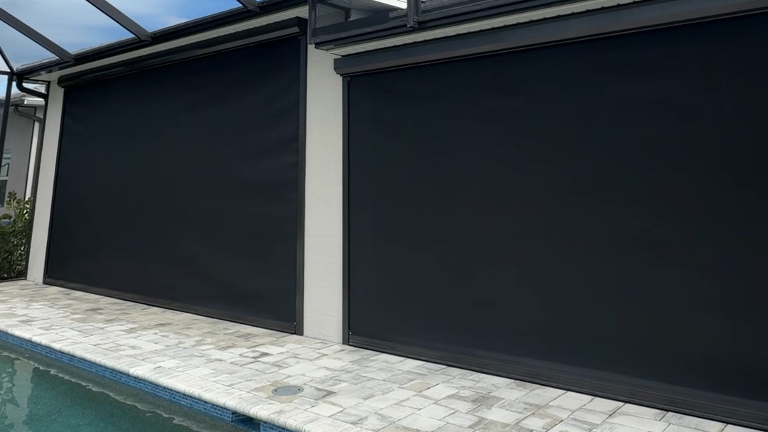 Lowered hurricane screens beside a swimming pool
